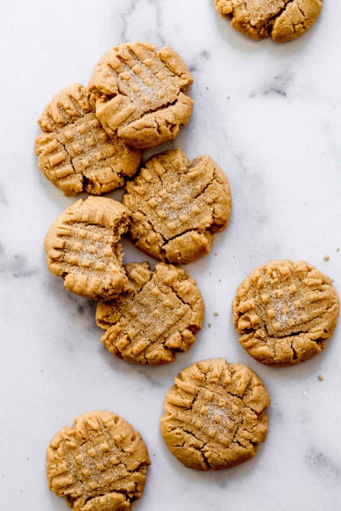 a few criss cross pattern peanut butter cookies arranged on a white surface