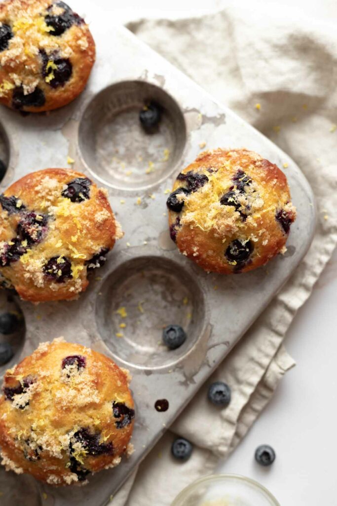 overhead view of baked lemon blueberry muffins in the muffin tin