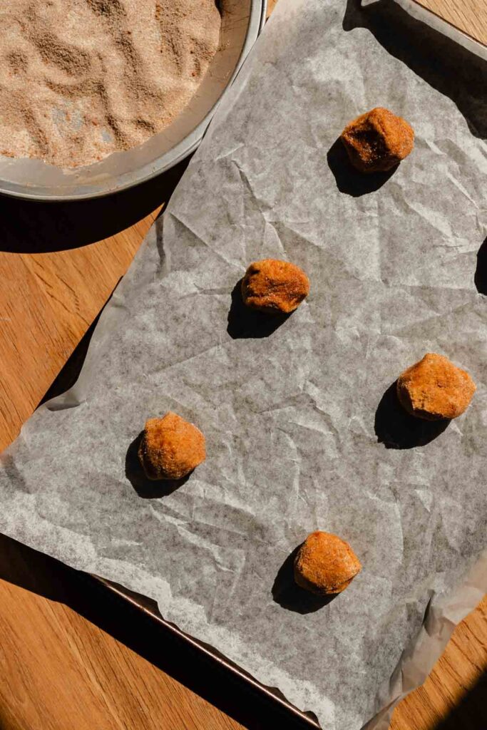 cookie dough balls arranged on a baking sheet